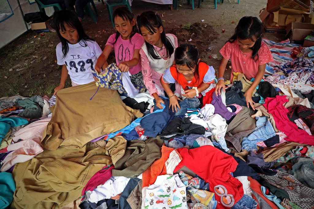 Sejumlah anak memilih baju layak pakai di pos pengungsian banjir bandang Kantor Kecamatan Baktiraja, Kabupaten Humbang Hasundutan, Sumatera Utara, Selasa (5/12).